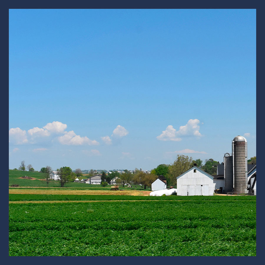 Paysage rural avec un bâtiment agricole en cours d’acquisition, illustrant l’achat d’un bien agricole en VEFA.